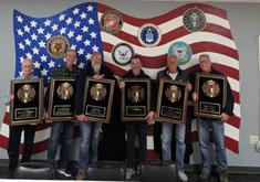 Six firemen stand as they are recognized for their years of service and retirement.