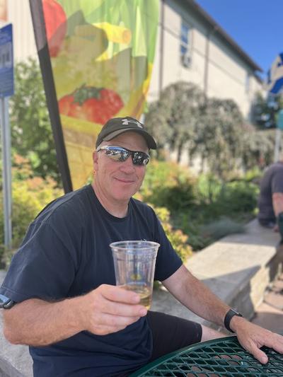 A farmers market vendor enjoys the social district at the farmers market