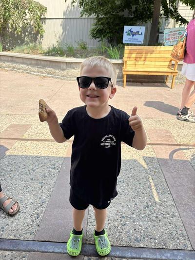 A young boy enjoys a cookie from the vendors